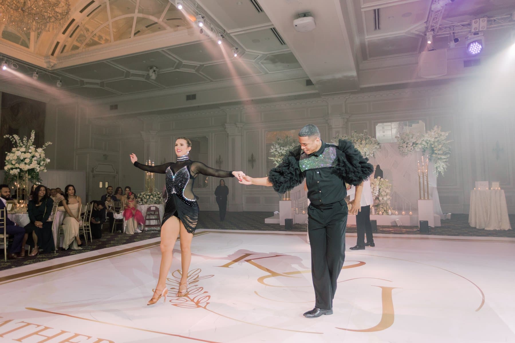 Molly Hagman and partner performing Latin dance at an elegant ballroom reception